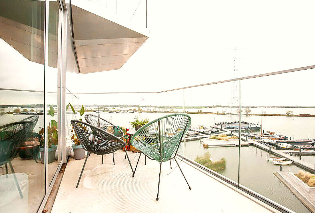Balcony with two chairs overlooking the open water