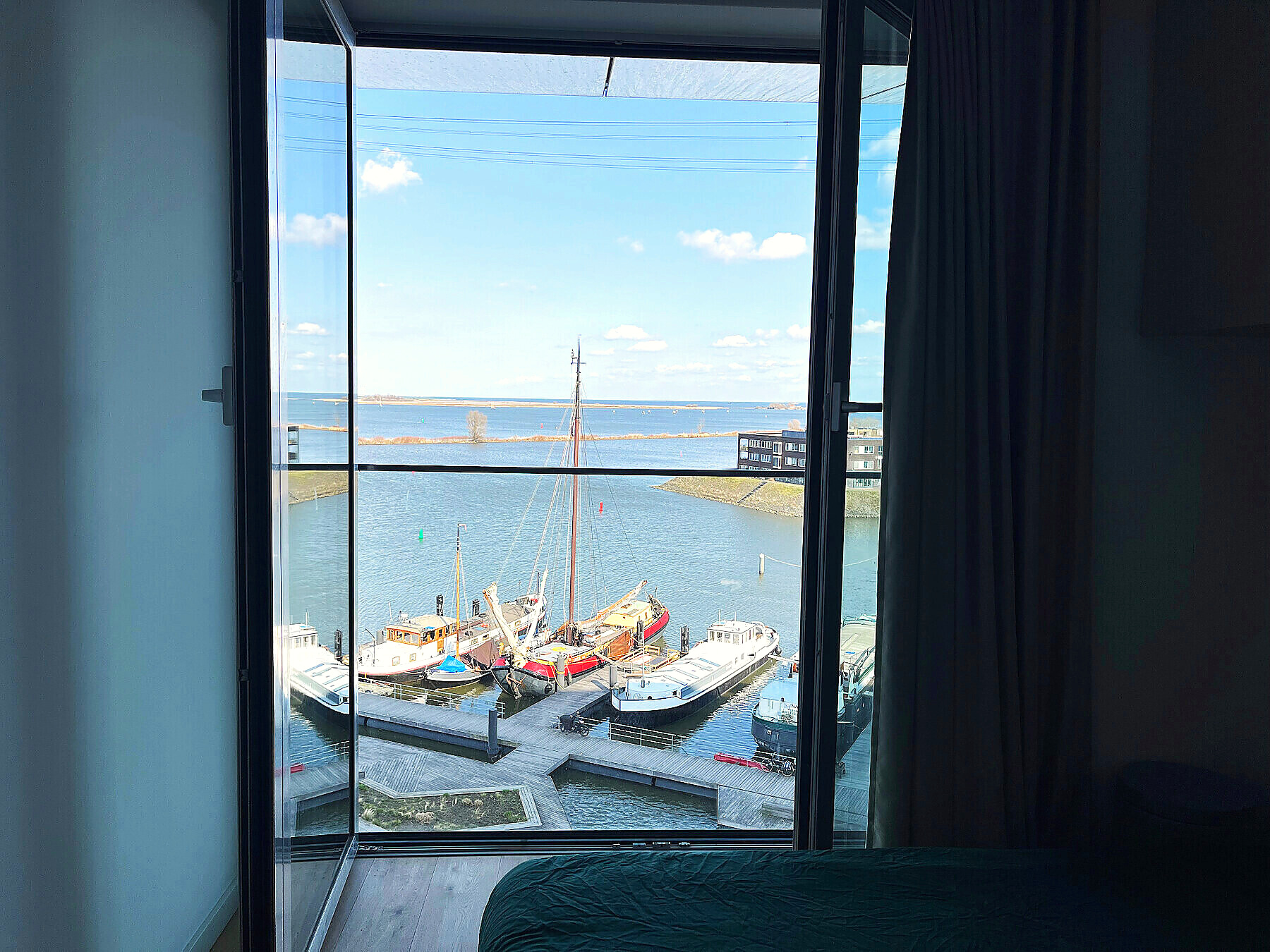 Peaceful bedroom window overlooking a tall ship on the water
