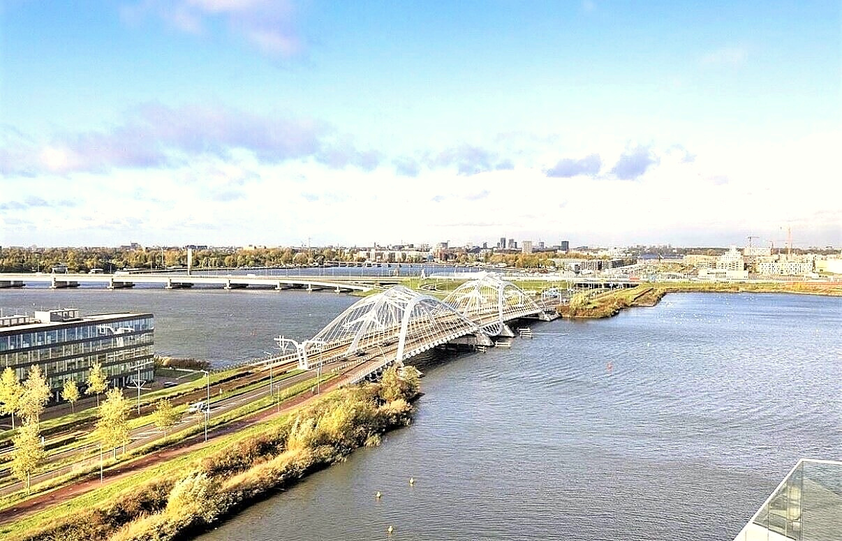 White arched bridge spanning the water toward the city