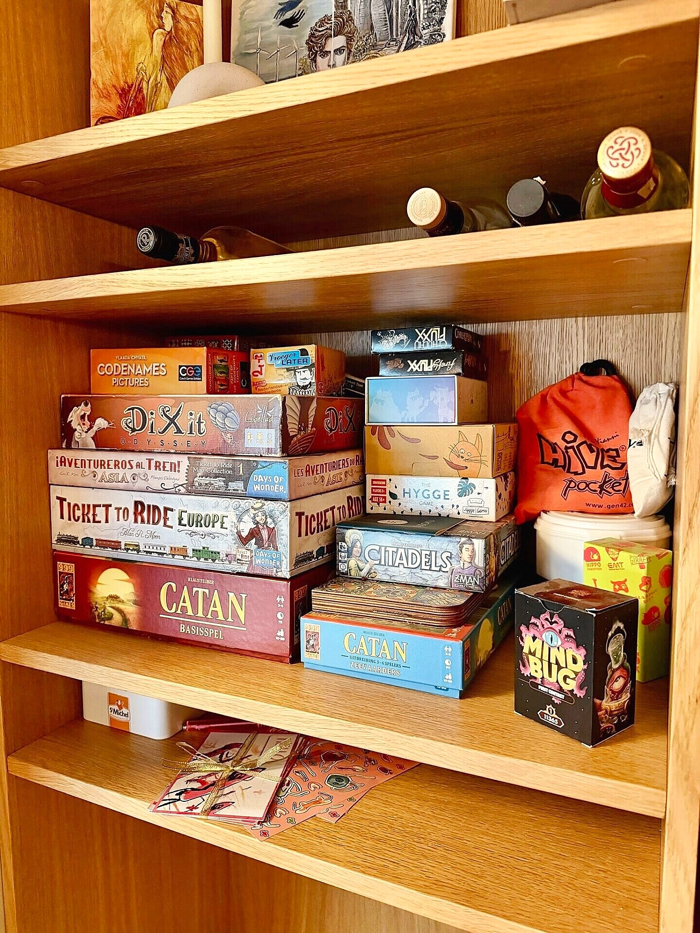 Curved oak shelves stacked with board games and bottles