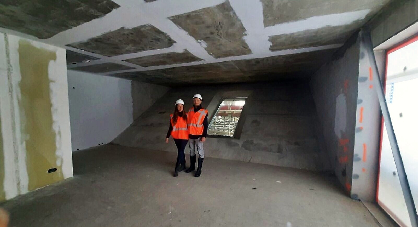 The raw concrete shell of the apartment on our first visit, hard hats on