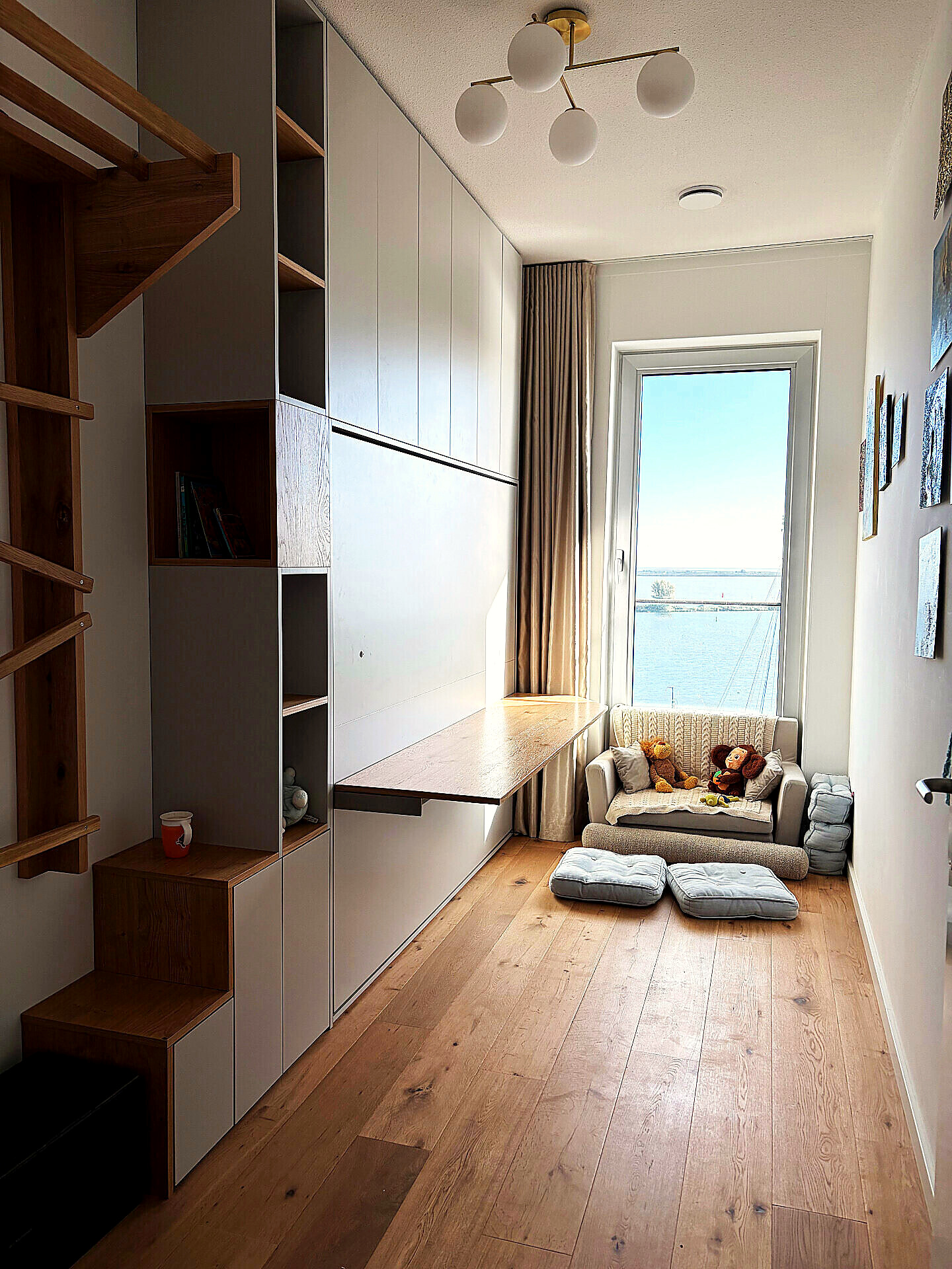 Multi-purpose room with built-in desk, storage and a small sofa facing the water