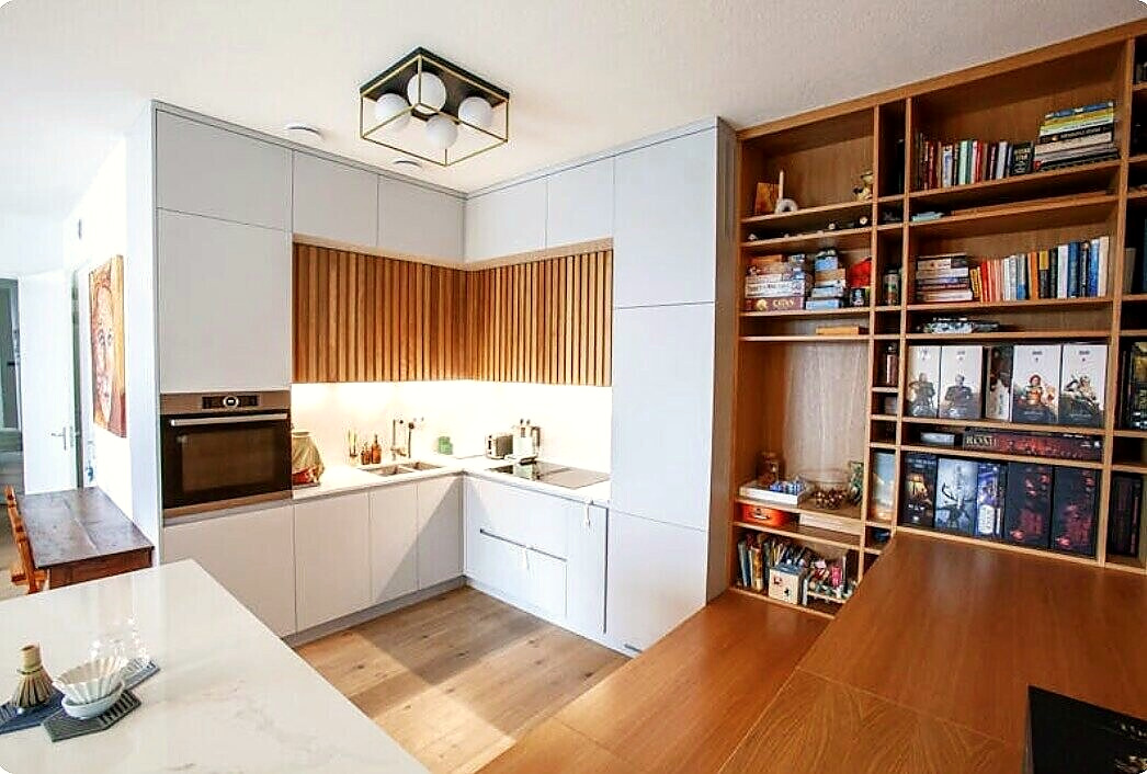 Kitchen with slatted oak fronts beside a tall oak bookcase