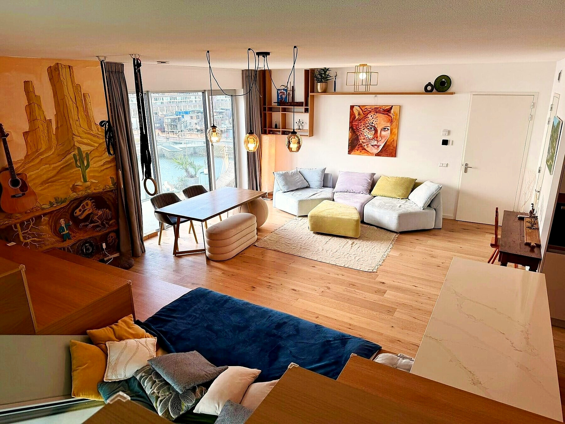 Open-plan living room with mural, modular sofa and timber interior