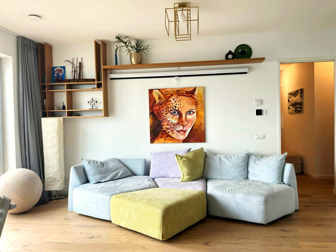 Lounge wall with a sofa that converts into a double bed and a painting above it